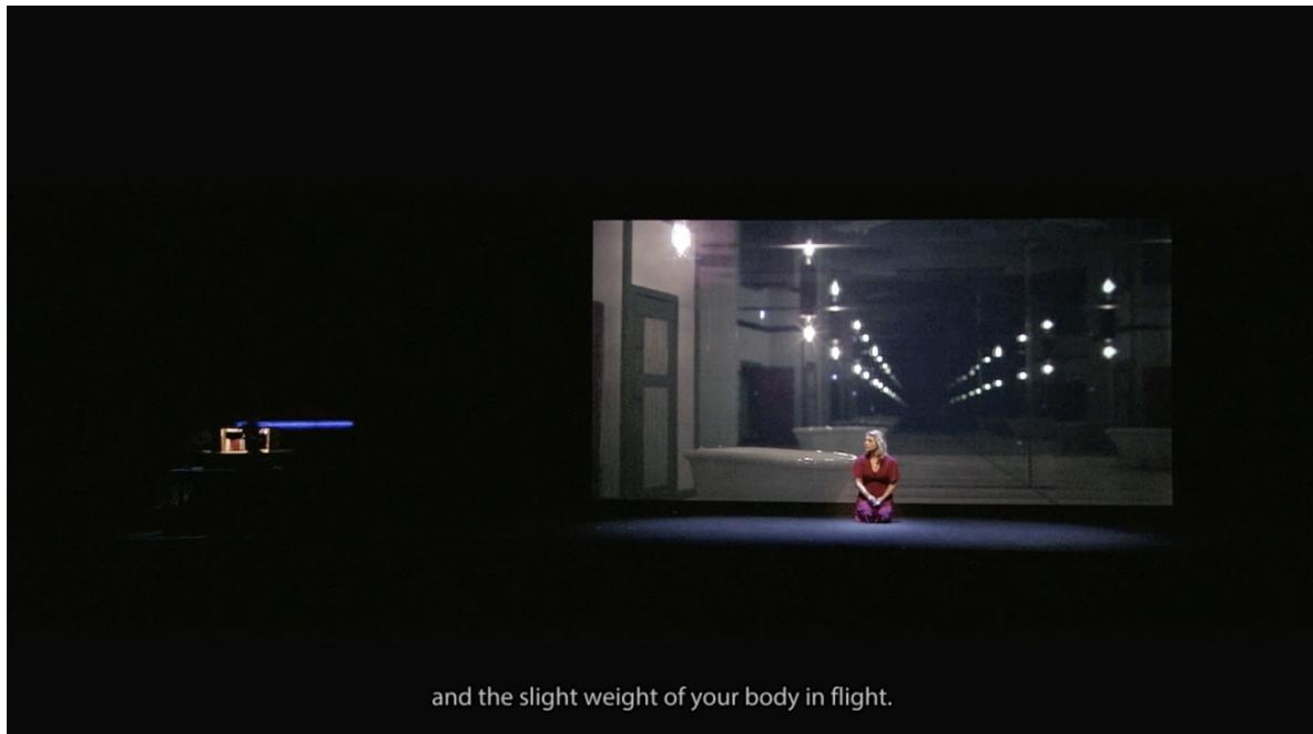 Abbildung 5: Miah Persson vor der Projektion des ›mise en abyme‹-Effekts in Van der Aas Blank Out, Scene 2-C, Screenshot (21:59) aus Teil 1 der Aufzeichnung der Produktion an De Nationale Opera (2016). Mit freundlicher Genehmigung von Michel van der Aa